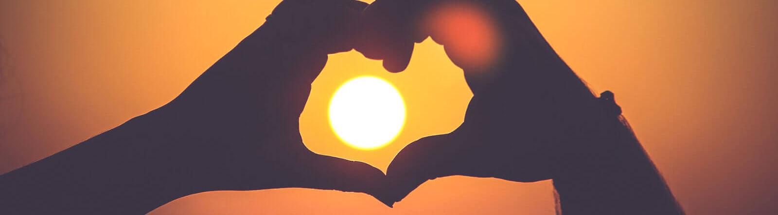 Herz-Händer im Sonnenuntergang