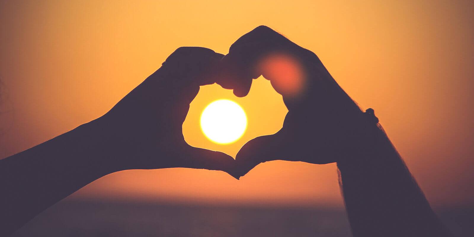 Herz-Händer im Sonnenuntergang