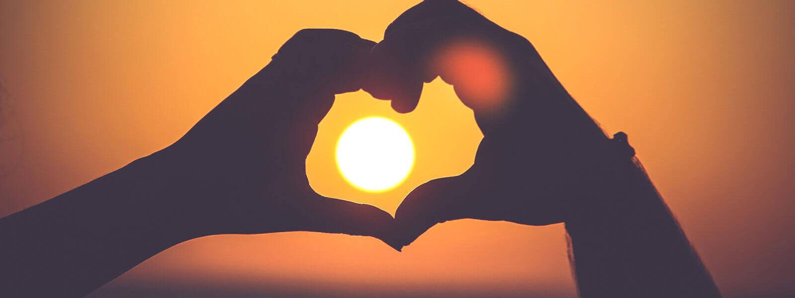 Herz-Händer im Sonnenuntergang