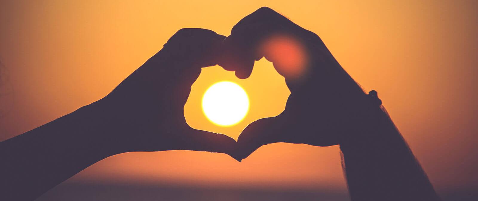 Herz-Händer im Sonnenuntergang